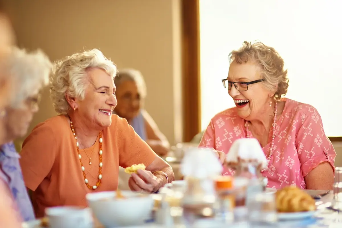 benefits-of-assisted-living-spokane-valley-fields-senior-living the benefits of assisted living you can see on smiling senior woman sitting with caregiver in a bright living room