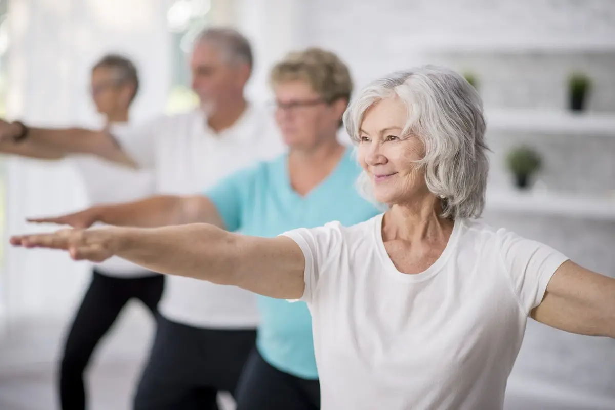 Assisted living activities: seniors stretch arms during a gentle group exercise class